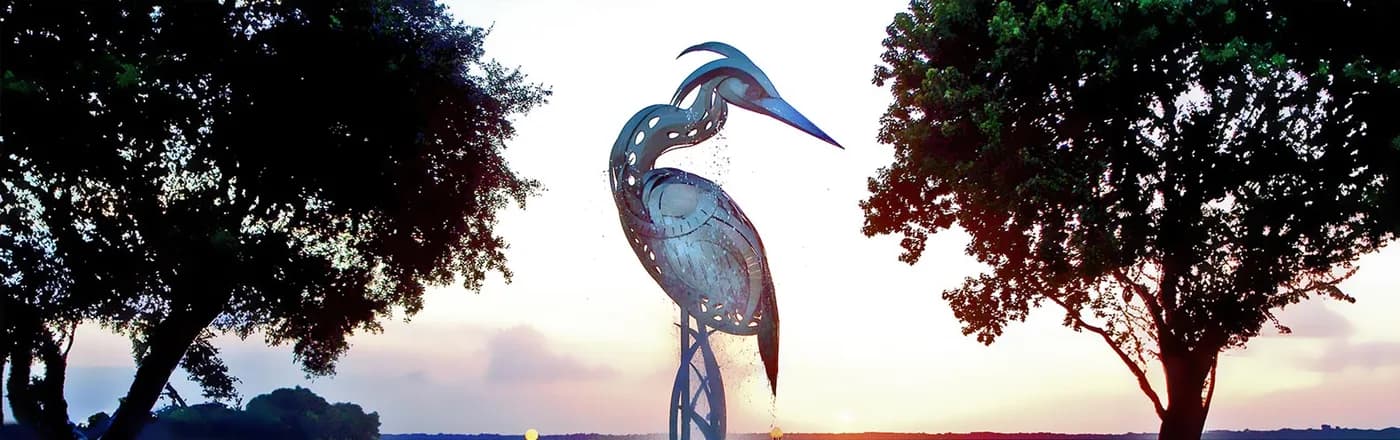 The heron statue fountain on Lake Eustis at sunset, Ferran Park