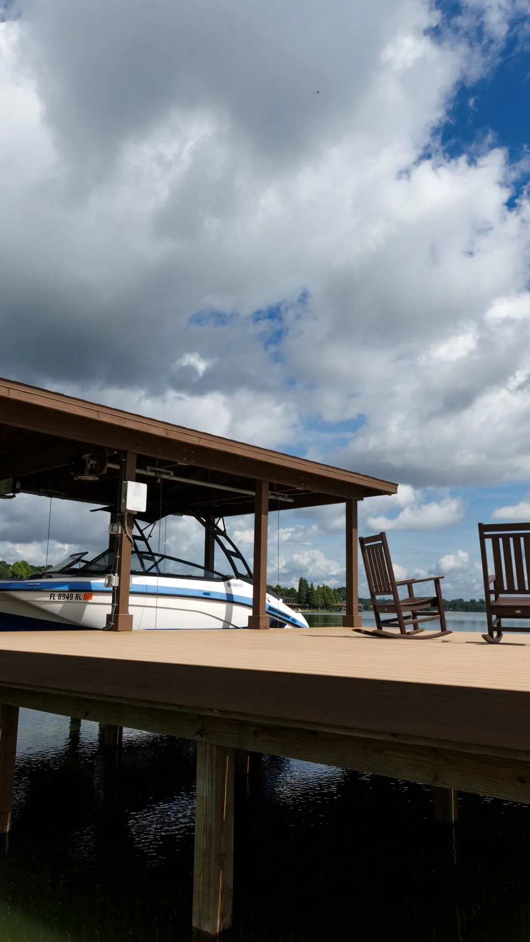 A covered boat dock with rocking chairs on the deck, open lake beyond — Horizon Marine, Central Florida